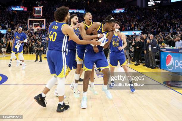 Kevon Looney of the Golden State Warriors is surrounded by teammates after he made the game-winning shot at the buzzer of double overtime to beat the...