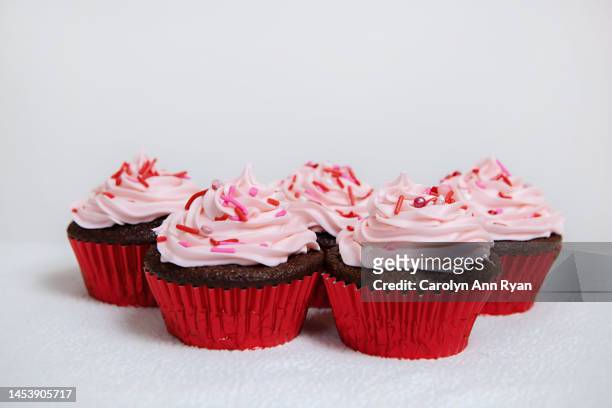 chocolate cupcakes with pink frosting and red sprinkles - forma de queque imagens e fotografias de stock