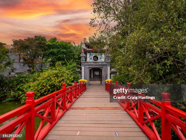 red bridge - huc bridge on hoan kiem lake, hanoi, vietnam. establishing shot for confucius turtle temple entrance at sunset - hanoi cityscape stock pictures, royalty-free photos & images