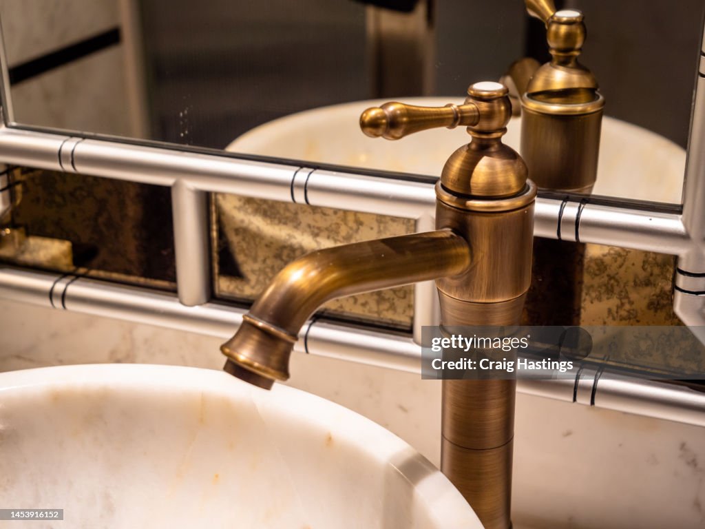 Vintage Gold Brass Mirror Faucet and Sink In Old-Fashioned Bathroom Art Deco style