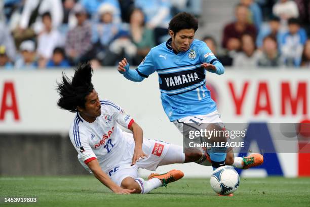 Takuya Matsuura of Jubilo Iwata is tackled by Yuji Nakazawa of Yokohama F.Marinos during the J.League J1 match between Jubilo Iwata and Yokohama...