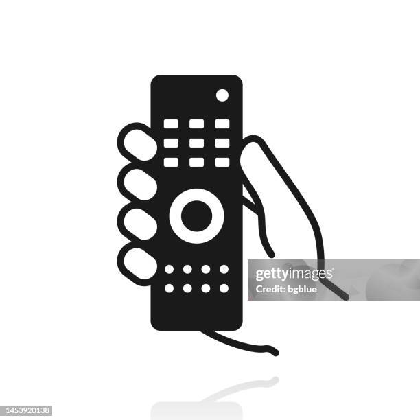 hand holding remote control. icon with reflection on white background - remote control stock illustrations