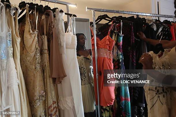 French actress Jessy Ugolin chooses a dress to try on during a dressing room session ahead of a red carpet event on the sidelines of the 65th Cannes...