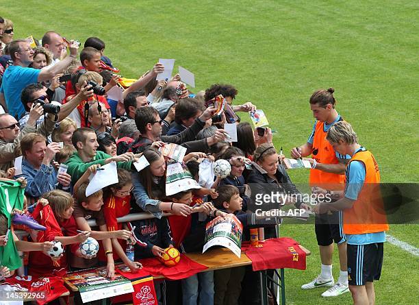 Spanish national football team players Sergio Ramos and Fernando Torres sign autographs on May 28, 2012 after a public training session in Schruns to...