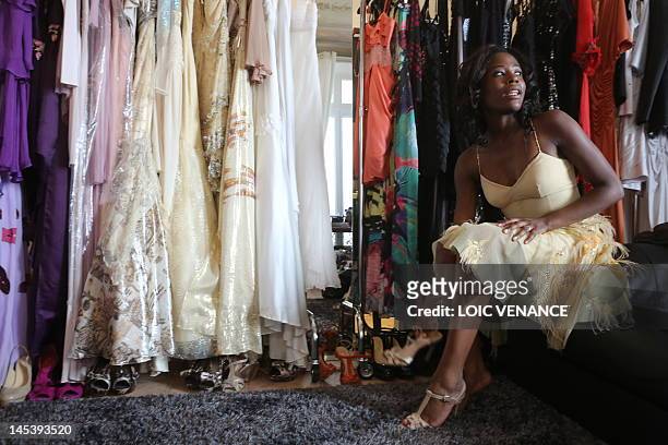 French actress Jessy Ugolin puts a shoe on during a dressing room session ahead of a red carpet event on the sidelines of the 65th Cannes film...