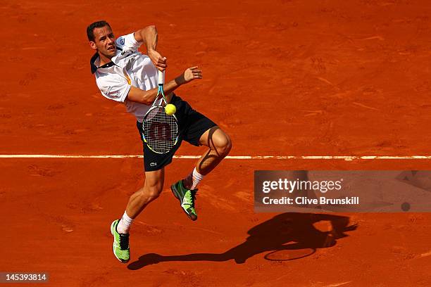 Michael Llodra of France leaps to volley the ball in the men's singles first round match between Michael Llodra of France and Guillermo Garcia-Lopez...