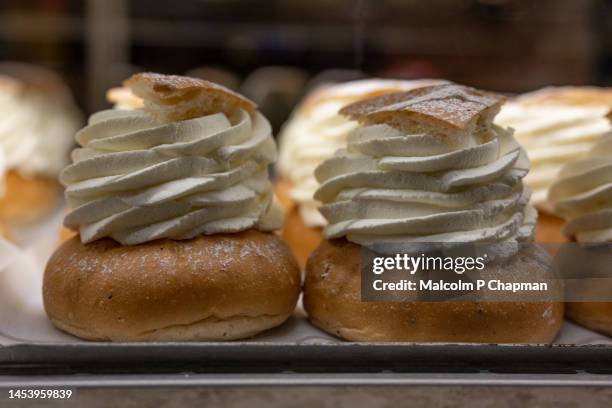 semlor or semla, cream buns with almond paste, eaten on, or before, shrove tuesday in sweden / scandinavia. also known as fastlagsbulle, laskiaispulla, vastlakukkel, fastelavnsbolle - pancake day - fotografias e filmes do acervo