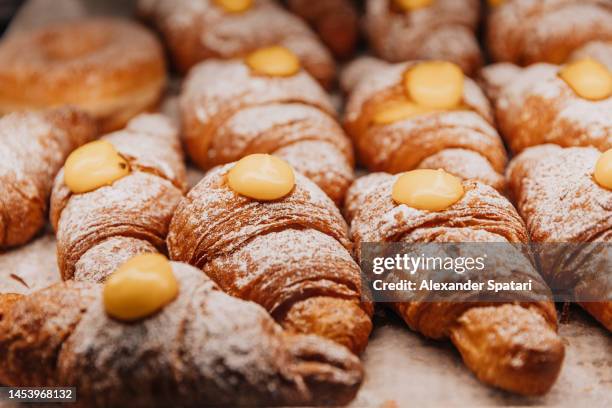 cornetti croissants with creme at the bakery close-up - vanillesoße stock-fotos und bilder