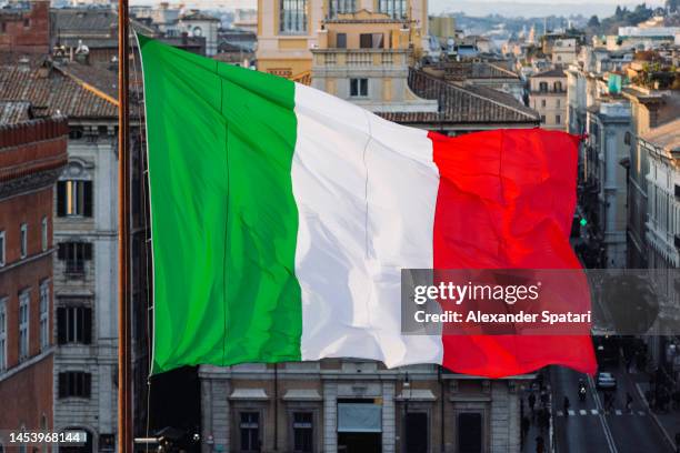 close-up of italian flag waving in the wind above rome skyline, italy - italian flag stock pictures, royalty-free photos & images