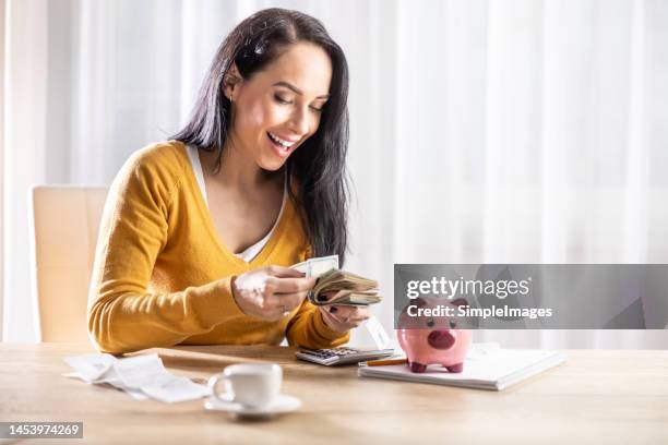 the american woman is counting the saved dollars at home, she is very happy that she did not miss all the bills, - sterling stock pictures, royalty-free photos & images