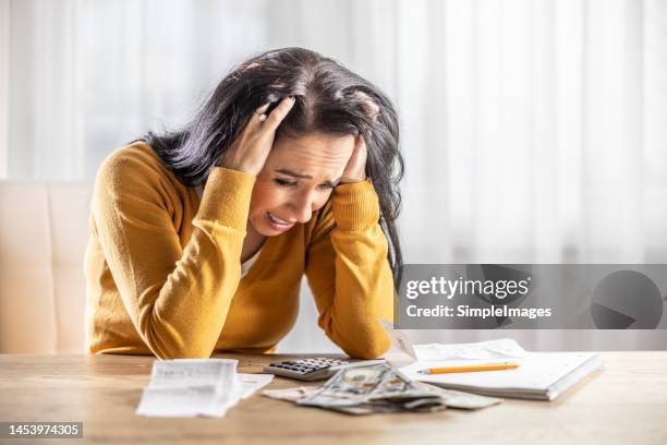 upset young woman looking at her shopping receipt and shocked at the price. - panik einkäufe stock-fotos und bilder