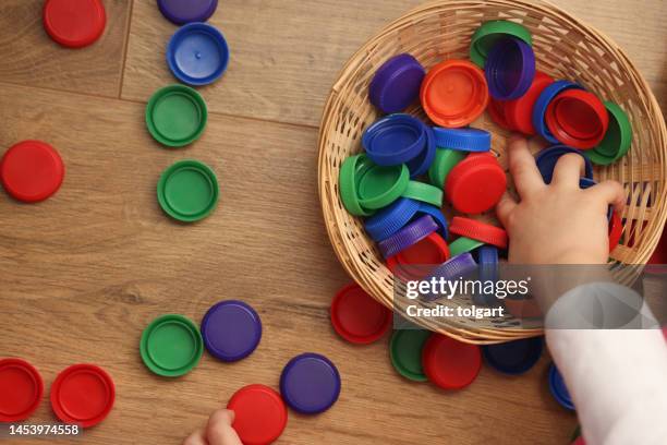 little girl playing plastic bottle caps - toys collection stock pictures, royalty-free photos & images