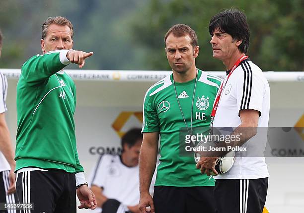 Head coach Joachim Loew and assistent coach Hans-Dieter Flick and goalkeeper coach Andreas Koepke chat during a Germany training session at Stadium...