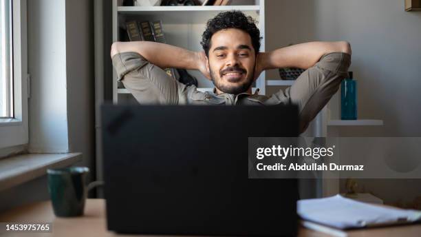 young man looks pleased to complete the job successfully - moeiteloos stockfoto's en -beelden