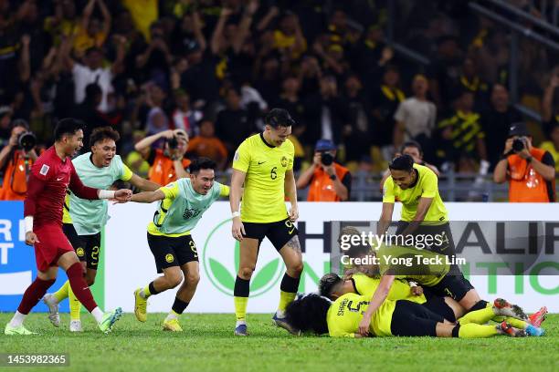 Stuart Wilkin of Malaysia celebrates with teammates after scoring a brace and the team's third goal against Singapore in the second half during the...