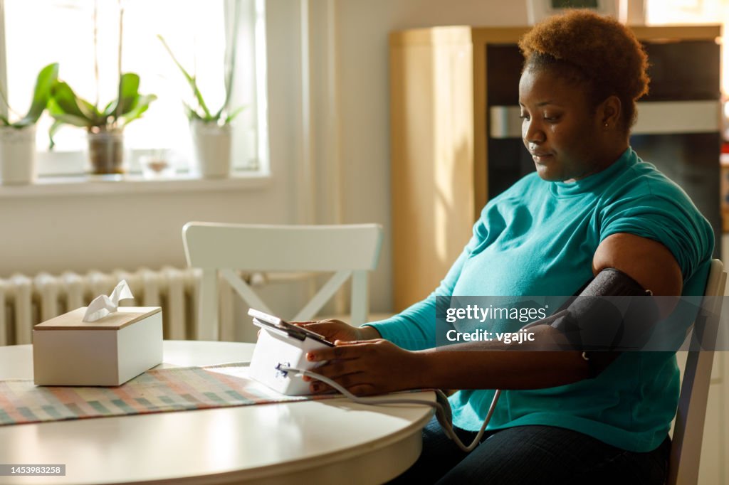 Young Woman Checks Her Blood Pressure At Home