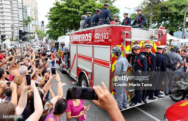 The coffin of Brazilian football legend Pelé is transported atop a fire truck as part of the funeral procession through the streets of Santos on the...