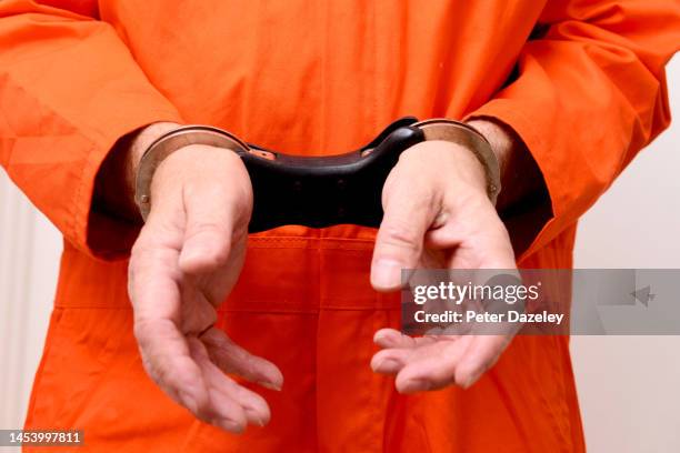 prisoner in handcuffs - jumpsuits stock pictures, royalty-free photos & images