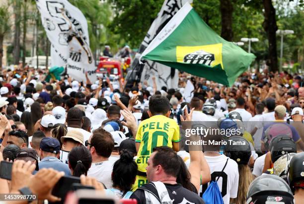 People follow the funeral procession of Brazilian football legend Pelé as his coffin is transported through the streets of Santos on the way to...