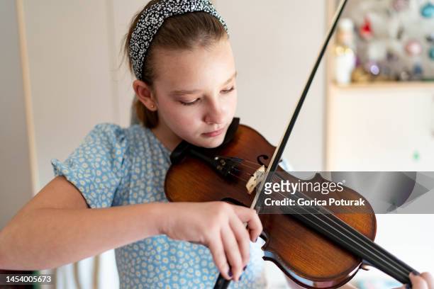 teenage girl playing violin at home - violinist stock pictures, royalty-free photos & images