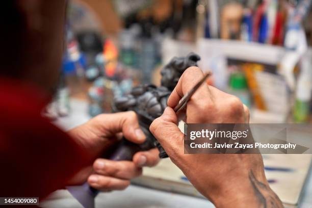 middle-aged latin man painting 3d printed figure - rpg maker stock pictures, royalty-free photos & images