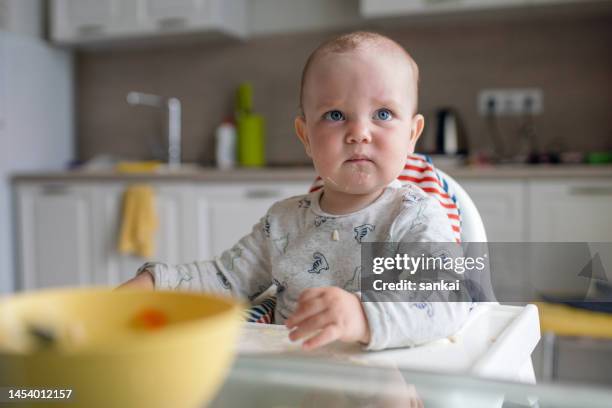 sulking baby boy at the dinner table - angry babies stock pictures, royalty-free photos & images