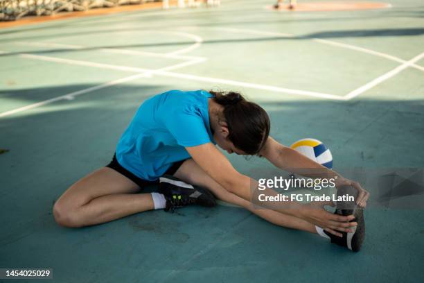 female volleyball player stretching at the volleyball court - leg stretch girl stock pictures, royalty-free photos & images