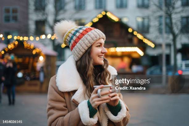 feliz mujer sonriente divirtiéndose en el mercado navideño - cup day one fotografías e imágenes de stock