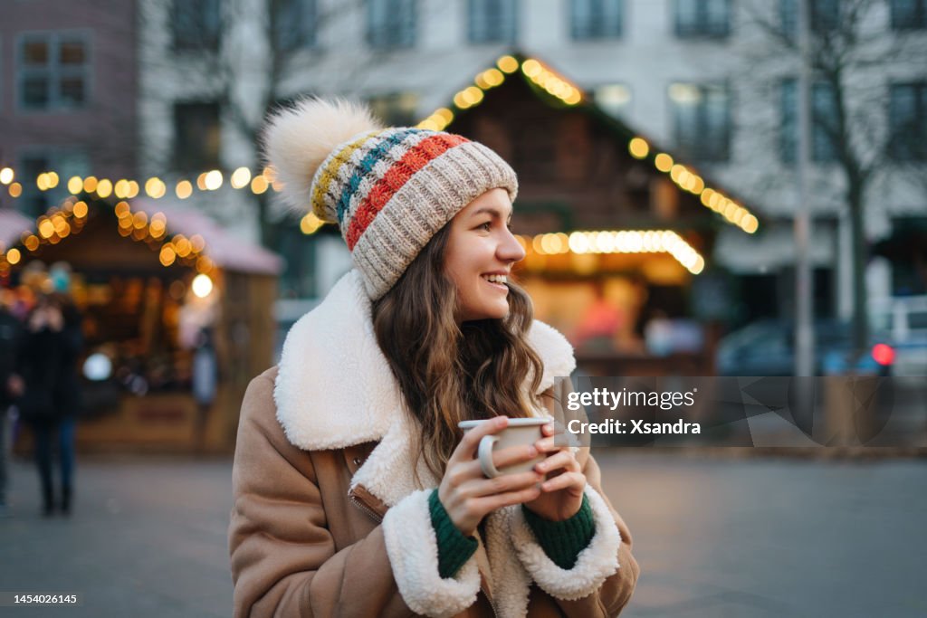 クリスマスマーケットで楽しむ幸せな笑顔の女性