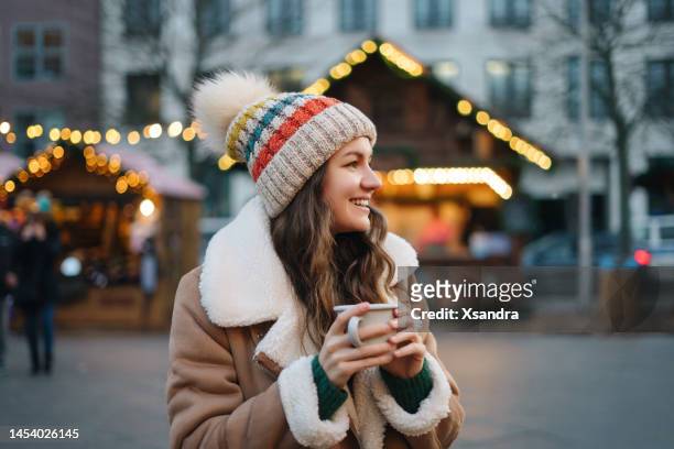 クリスマスマーケットで楽しむ幸せな笑顔の女性 - ホットワイン ストックフォトと画像