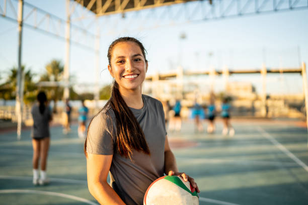 portrait of female volleyball player holding a volleyball ball at sports court - girls volleyball stock pictures, royalty-free photos & images
