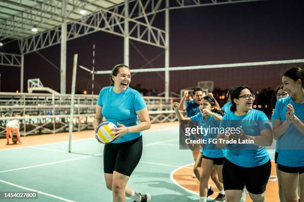 female volleyball talking after finish of training or celebrating victory after game at sports court - girls volleyball stock pictures, royalty-free photos & images