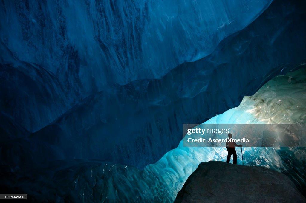 Man inside a glacial ice cave