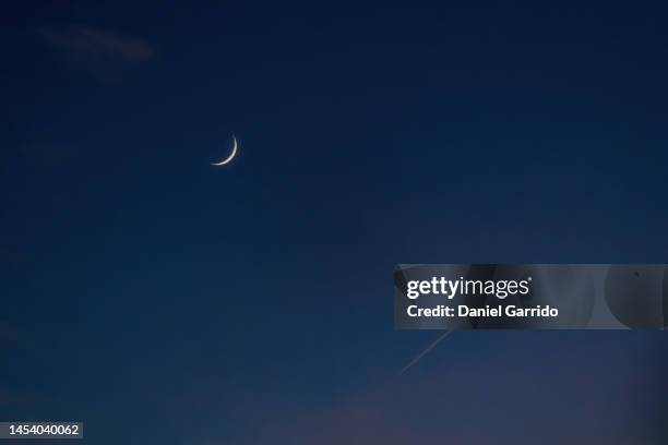 crescent moon during sunset next to the wake of an airplane, backgrounds - crescent stock pictures, royalty-free photos & images