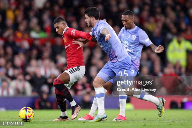 Marcus Rashford of Manchester United is challenged by Marcos Senesi of AFC Bournemouth during the Premier League match between Manchester United and...