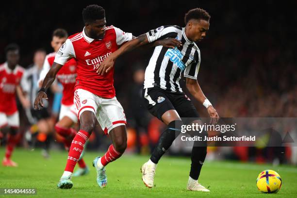Thomas Partey of Arsenal is challenged by Joe Willock of Newcastle United during the Premier League match between Arsenal FC and Newcastle United at...