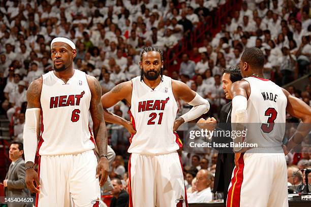 LeBron James, Ronny Turiaf and Dwyane Wade of the Miami Heat receive direction from Head Coach Erik Spoelstra during a break in the action against...