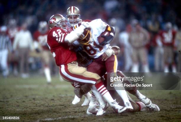Washington, D.C. Ronnie Lott of the San Francisco 49ers tackles Art Monk the Washington Redskins during an NFL football game November 17, 1986 at...