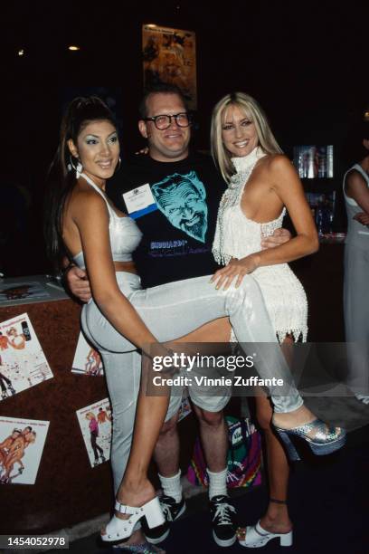 Drew Carey poses with two entertainers at the Annual Video Software Dealers Association Convention and Expo, held at the Las Vegas Convention Center...