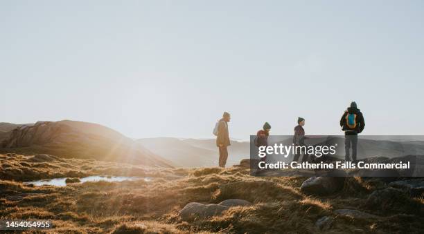 a young family enjoy the view from the top of a mountain - trekking fotografías e imágenes de stock