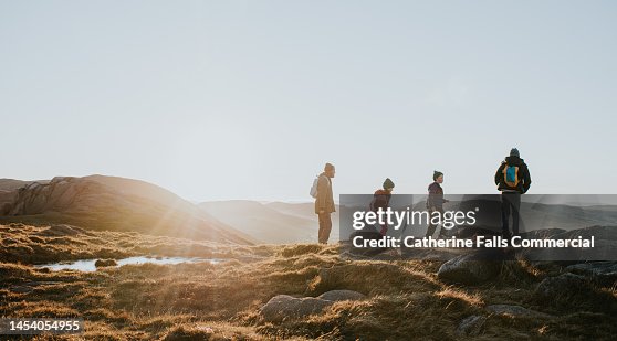 A young family enjoy the view from the top of a mountain