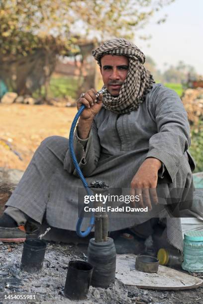 An Egyptian farmer smokes hookah in the Egyptian countryside on January 3, 2023 in Giza, Egypt.