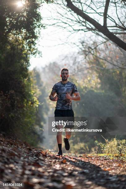 atleta masculino corriendo a campo traviesa temprano en la mañana - cross country running fotografías e imágenes de stock