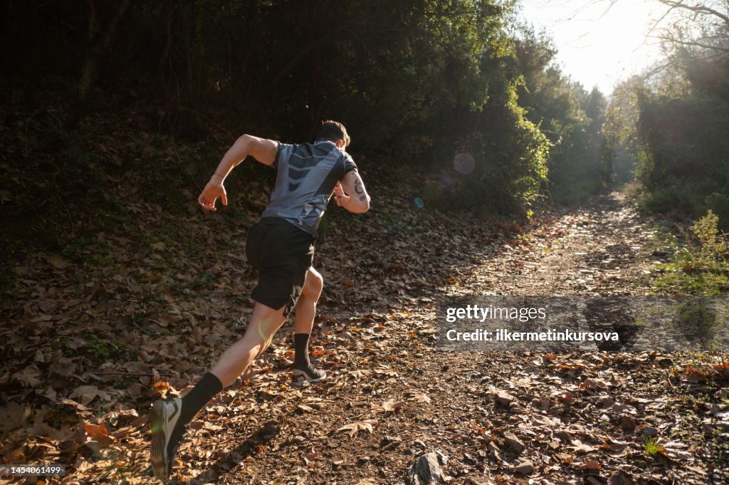 Male athlete running cross-country in the early morning