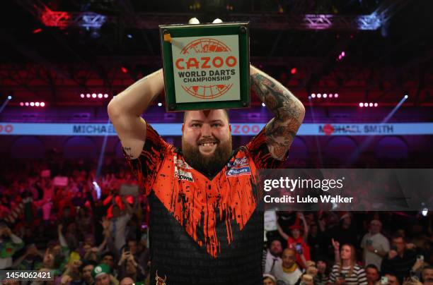 Michael Smith of England celebrates with the Trophy during the Finals against Michael van Gerwen of Netherlands during Day Fourteen of the Cazoo...