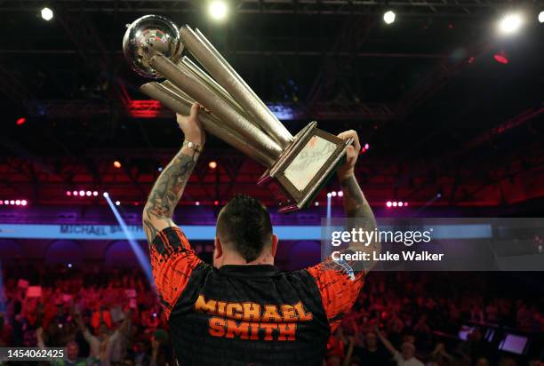 Michael Smith of England celebrates with the Trophy during the Finals against Michael van Gerwen of Netherlands during Day Fourteen of the Cazoo...