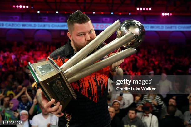 Michael Smith of England celebrates with the Trophy during the Finals against Michael van Gerwen of Netherlands during Day Fourteen of the Cazoo...