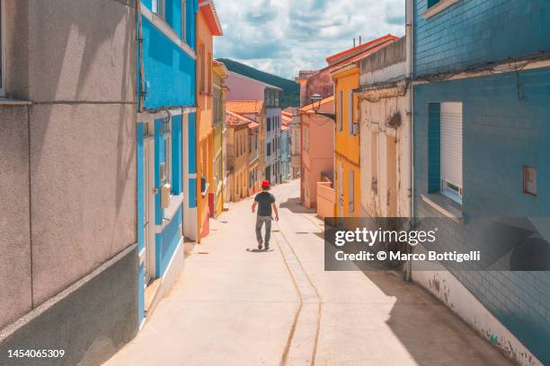 person walking in the street among colorful houses - wonderlust stock pictures, royalty-free photos & images