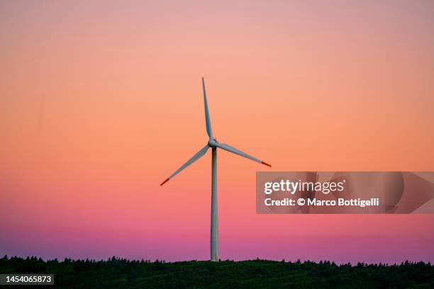 wind turbines against low clouds at dawn - red-windmill stock pictures, royalty-free photos & images