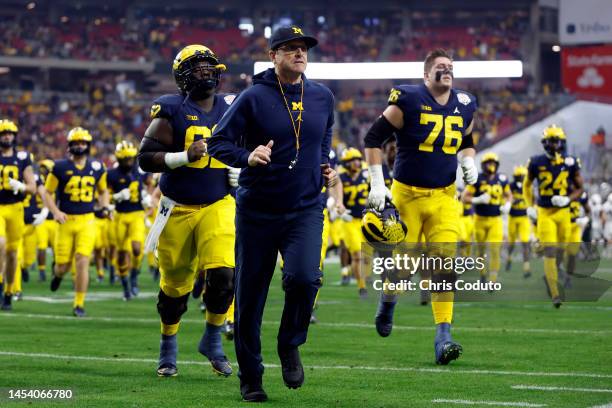 Head coach Jim Harbaugh of the Michigan Wolverines leaves the field before the Vrbo Fiesta Bowl against the TCU Horned Frogs at State Farm Stadium on...